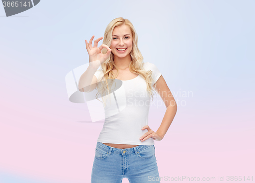 Image of happy young woman in white t-shirt showing ok sign