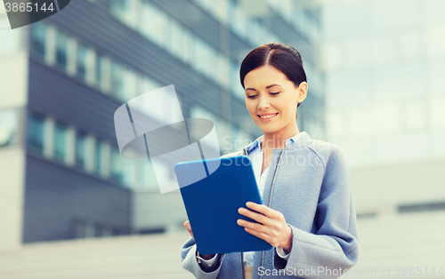 Image of smiling business woman with tablet pc in city