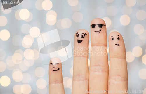 Image of close up of four fingers with smiley faces