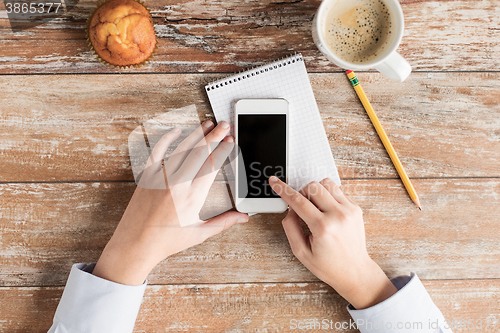 Image of close up of hands with smartphone and coffee cup