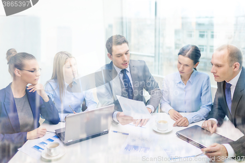 Image of business team with laptop having discussion