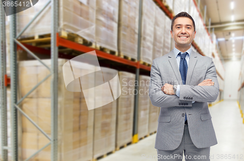 Image of happy man in suit and tie over warehouse