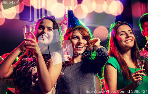 Image of smiling friends with glasses of champagne in club