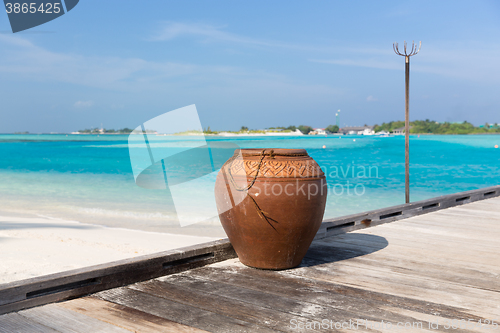 Image of maldives island beach with vase on wood flooring