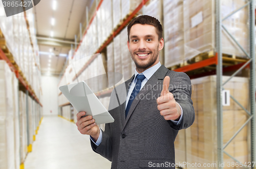 Image of businessman with tablet pc over warehouse