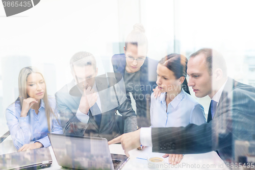 Image of business team with laptop having discussion