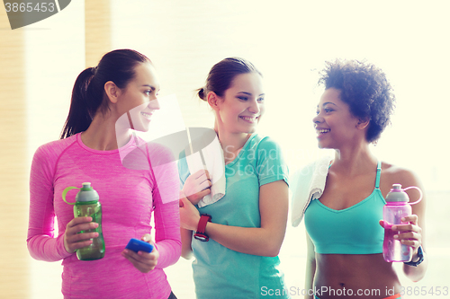 Image of happy women with bottles of water in gym