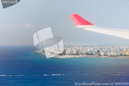 Image of close up of airplane wing above Maldives and ocean