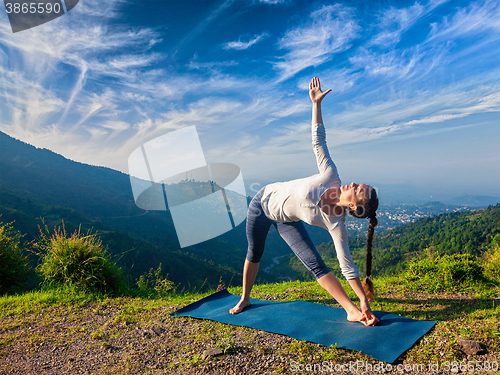 Image of Woman doing Ashtanga Vinyasa yoga asana Utthita trikonasana