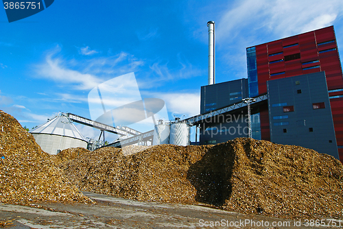 Image of bio power plant with storage of wooden fuel (biomass) against bl