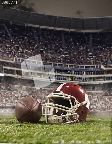 Image of The ball of american football players and helmet on stadium background