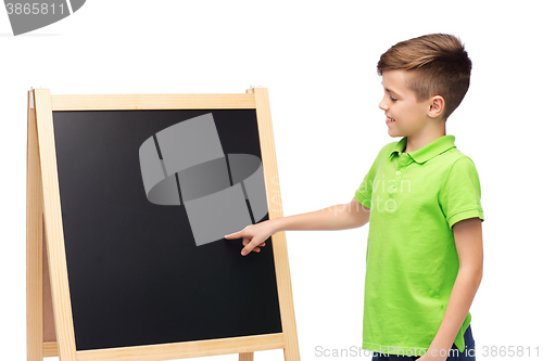 Image of happy boy with chalk and blank school blackboard