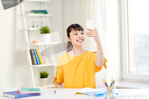 Image of asian woman student taking selfie with smartphone