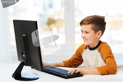 Image of smiling boy with computer at home