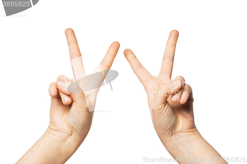 Image of close up of hands showing peace or victory sign