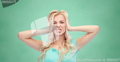 Image of young woman holding to her head and screaming