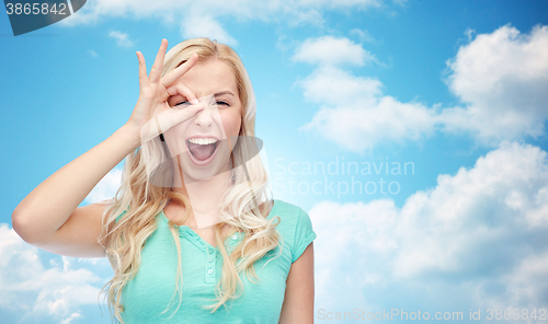 Image of young woman making ok hand gesture