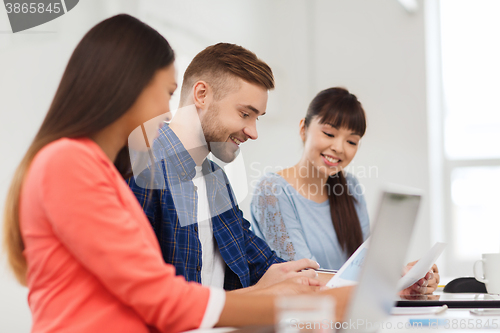 Image of happy creative team or students working at office