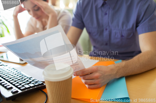 Image of close up of creative team with papers in office
