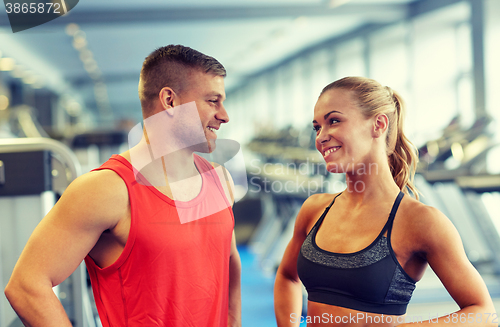 Image of smiling man and woman talking in gym