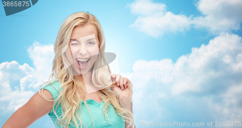 Image of smiling young woman holding her strand of hair