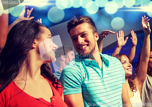 Image of smiling friends at concert in club