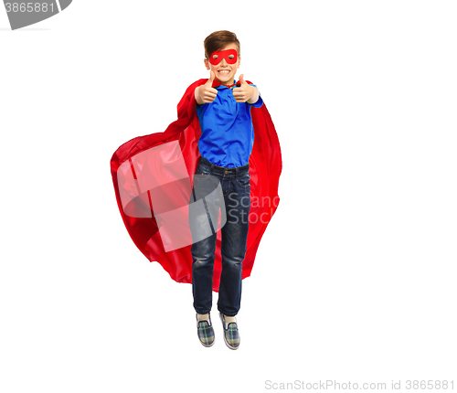 Image of boy in super hero cape and mask showing thumbs up