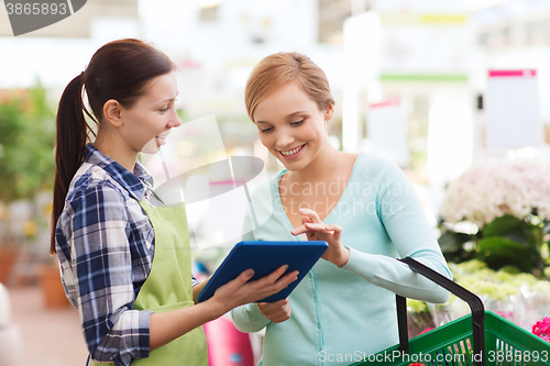 Image of happy women with tablet pc in greenhouse