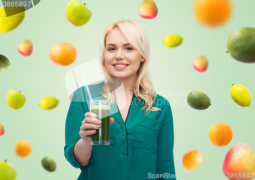 Image of smiling woman drinking vegetable juice or smoothie