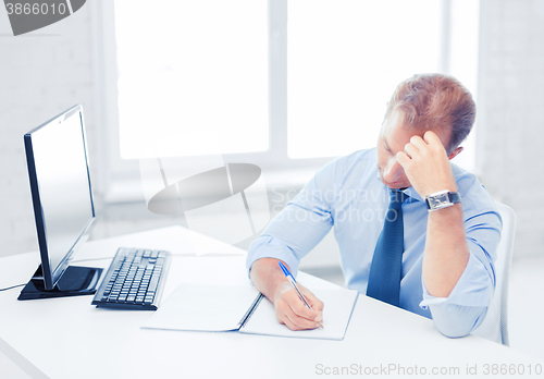 Image of businessman with notebook and computer