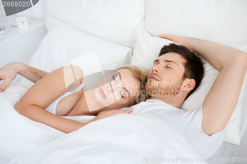 Image of happy couple sleeping in bed at home