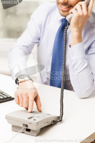 Image of businessman dialing number and calling on phone