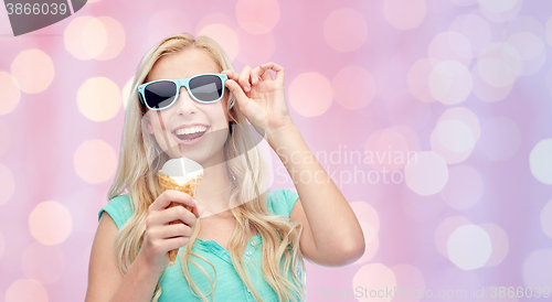 Image of happy young woman in sunglasses eating ice cream