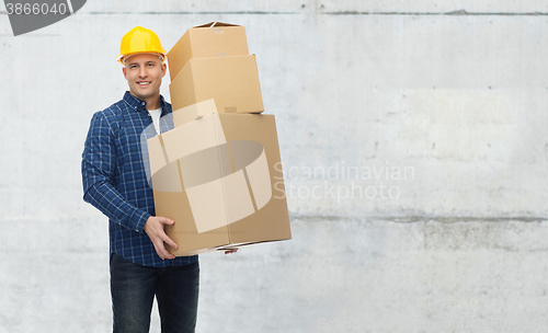 Image of smiling man in helmet with cardboard boxes