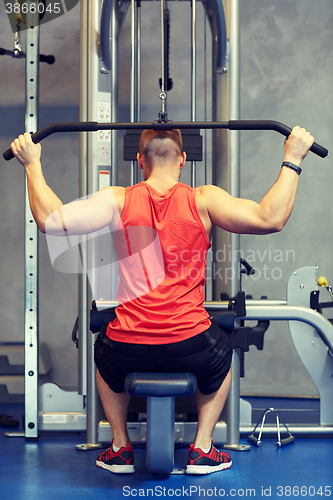 Image of man flexing muscles on cable machine gym