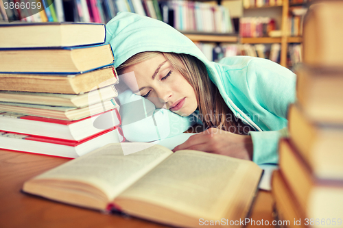 Image of student or woman with books sleeping in library