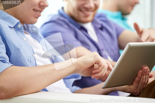 Image of close up of happy friends with tablet pc at home