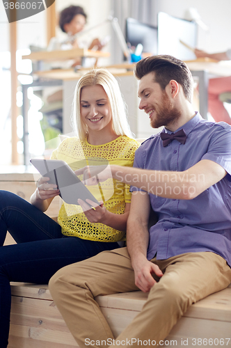Image of happy creative team with tablet pc in office