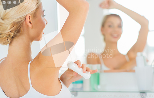 Image of woman with antiperspirant deodorant at bathroom