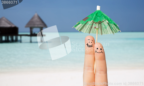 Image of close up of two fingers with cocktail umbrella