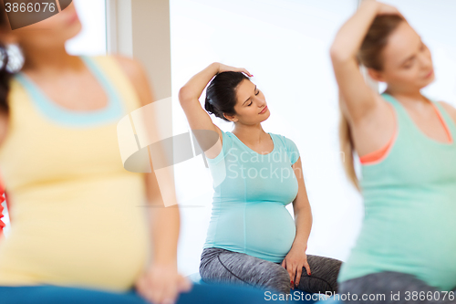 Image of happy pregnant women exercising on fitball in gym