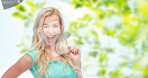 Image of smiling young woman holding her strand of hair