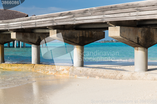 Image of bridge on stilts at exotic resort beach