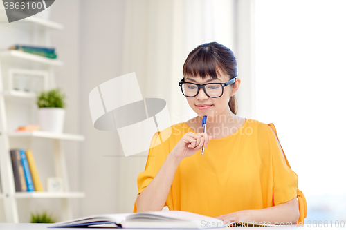 Image of happy asian young woman student learning at home