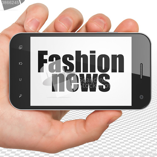 Image of News concept: Hand Holding Smartphone with Fashion News on display