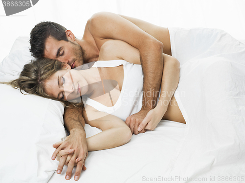 Image of romantic couple sleeping in a white bed