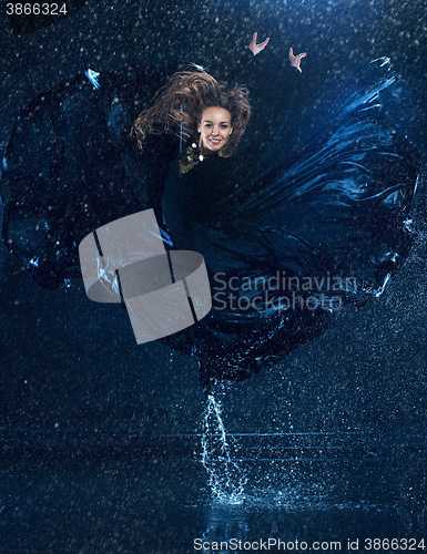 Image of The young beautiful modern dancer dancing under water drops