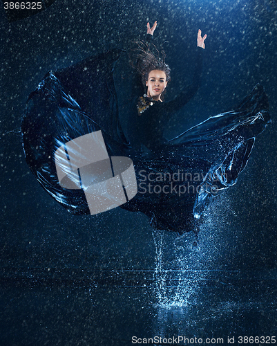 Image of The young beautiful modern dancer dancing under water drops