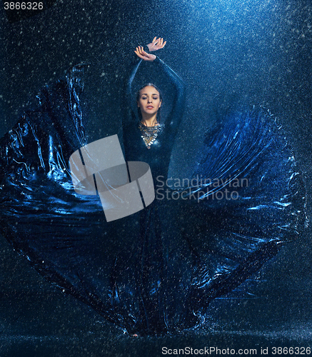 Image of The young beautiful modern dancer dancing under water drops