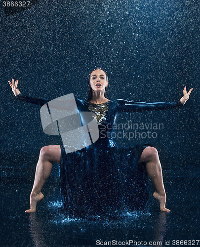 Image of The young beautiful modern dancer dancing under water drops